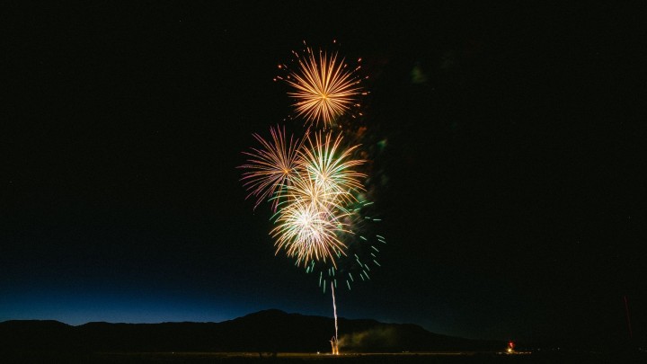 Colorful fireworks over dark landscape at night