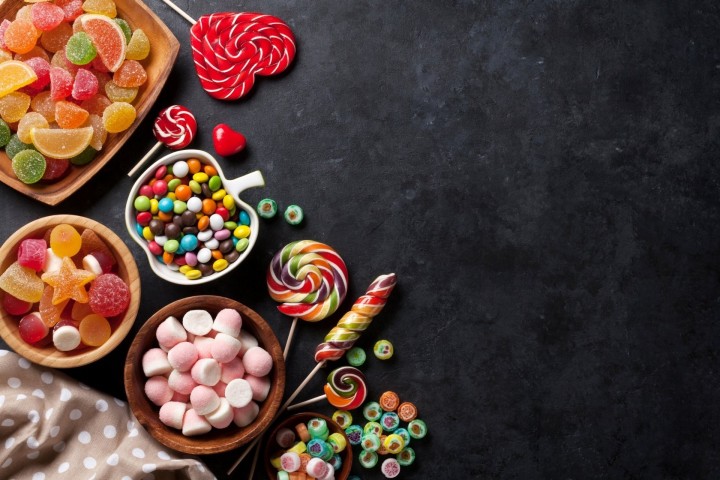 Colorful lollipops and candies on blue background