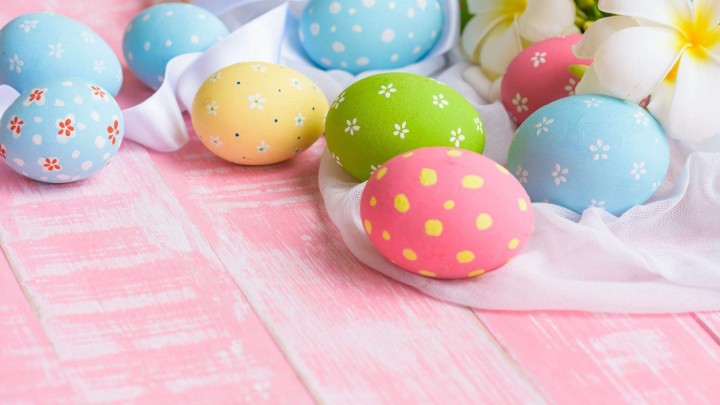 Colorful painted Easter eggs on pink wooden background