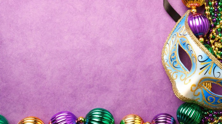 Gold Mardi Gras mask beads and fleur de lis on yellow