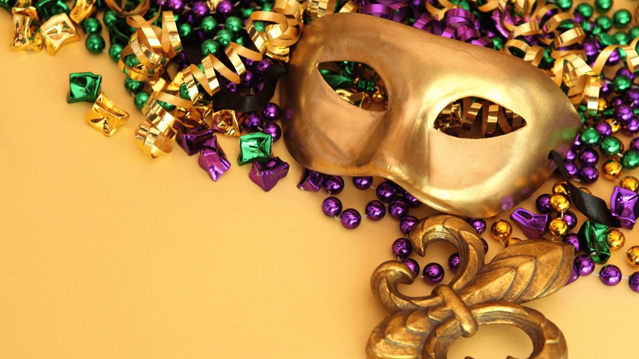 Mardi Gras mask and beads on purple background