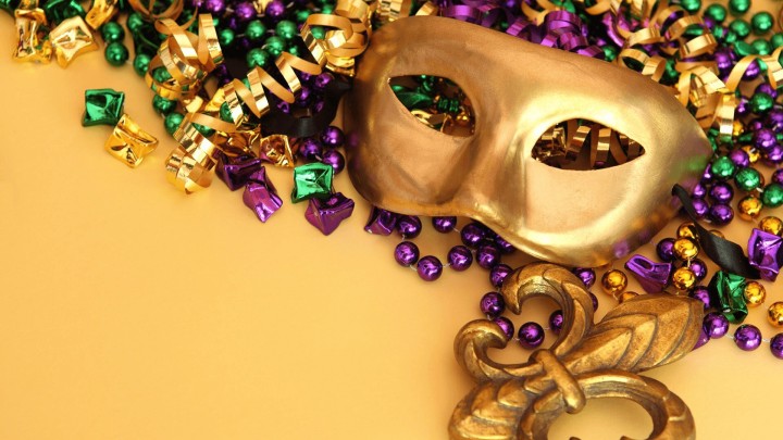 Mardi Gras mask and beads on purple background