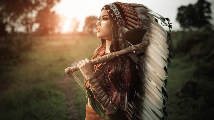 Native American woman aiming bow and arrow