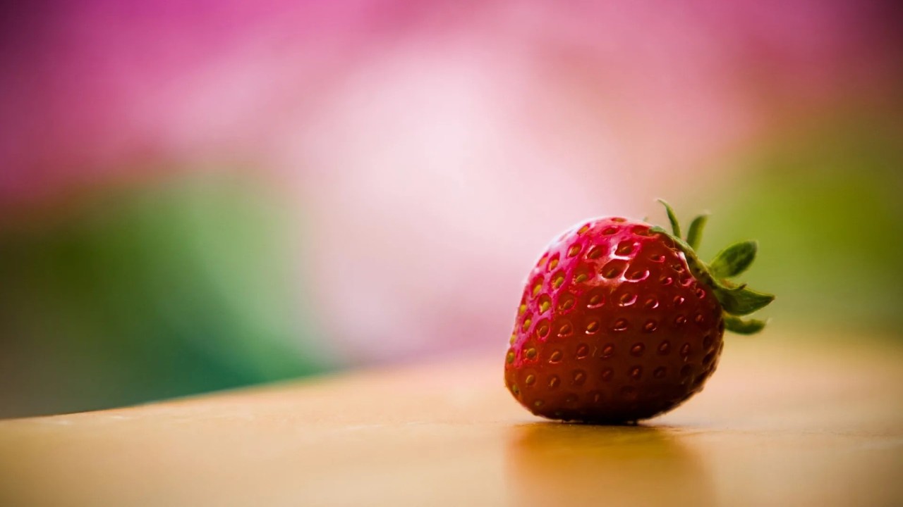 Red strawberry close up on a wooden surface