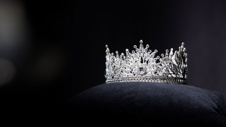 Silver jeweled crown on dark background