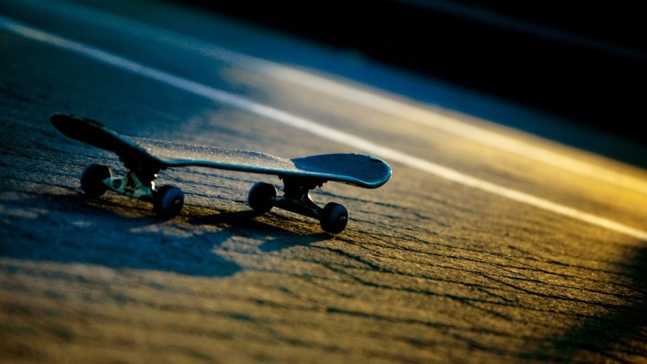 Skateboard on the ground at sunset low angle