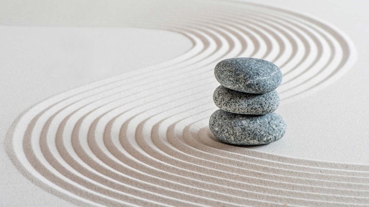 Stacked stones on raked sand in a Zen garden