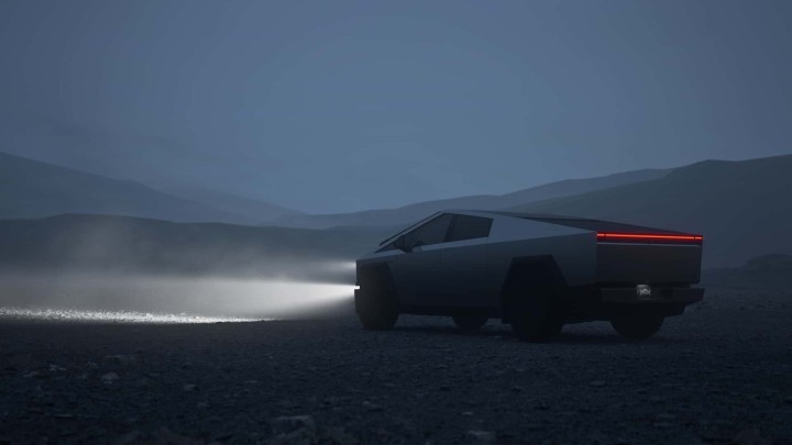 Tesla Cybertruck in dark landscape with headlights on