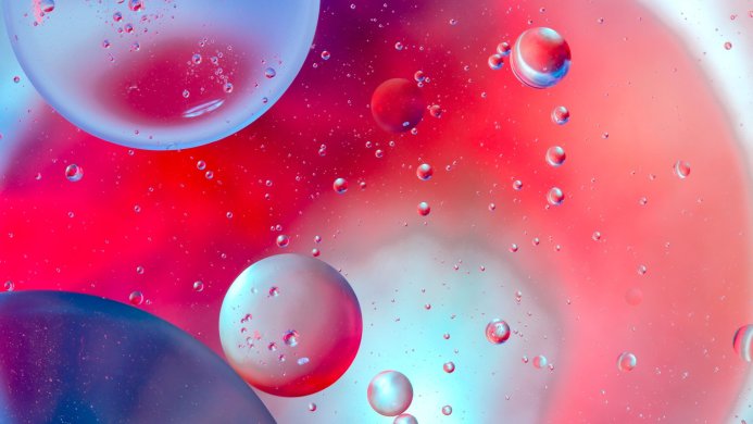 Abstract image of oil drops in water with red, blue, and white colors