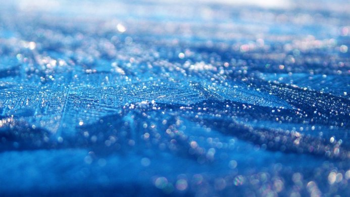 Close-up of blue ice crystals with bokeh highlights