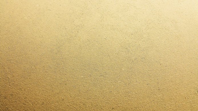 A wall surface of brown and yellow hues with a rough texture