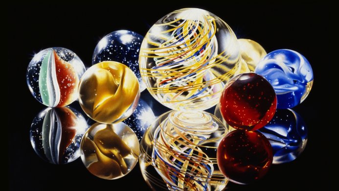Collection of colorful marbles reflecting on a black surface