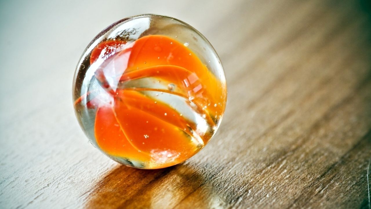 Close up of a glass marble with orange swirl pattern