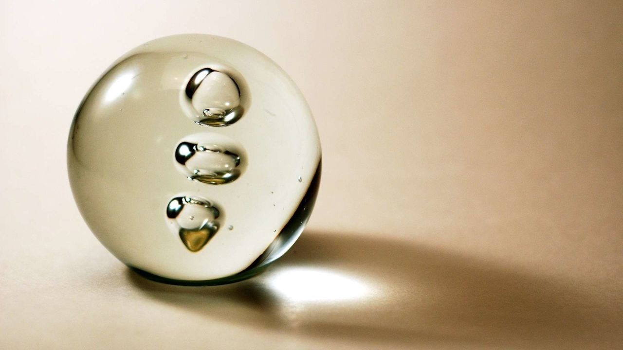Glass paperweight with bubbles casting a shadow