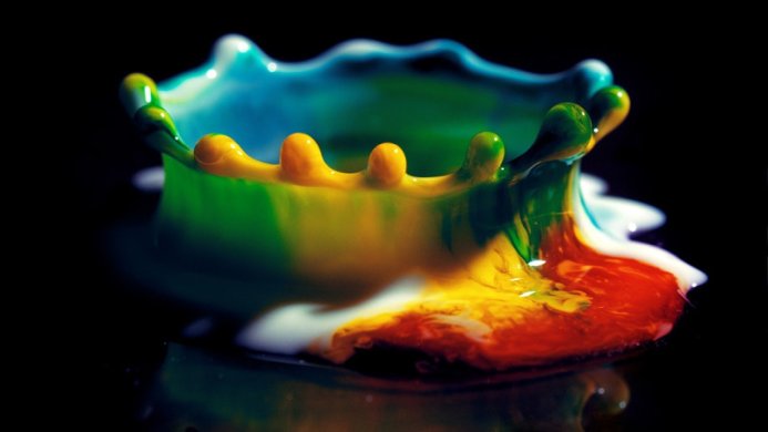 A vibrant multicolored liquid splash against a black background