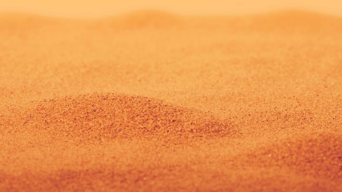 Close-up of sand with blurred background showing the texture and pattern