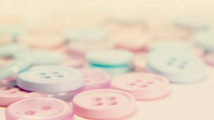 Close-up of pastel pink and blue buttons on a light background