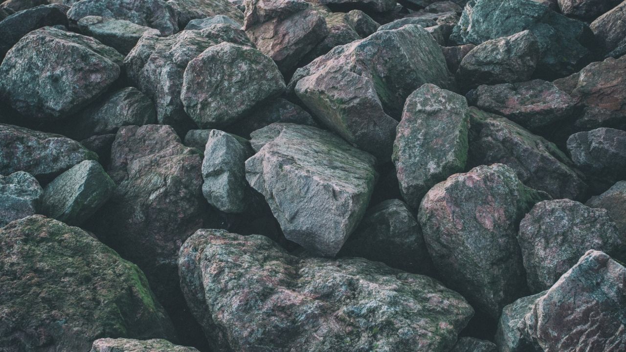 Pile of large weathered rocks with moss texture