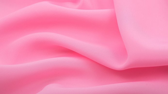 Close-up of pink fabric with soft folds and curves