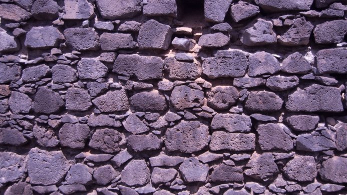 A wall made of irregularly shaped purple stones