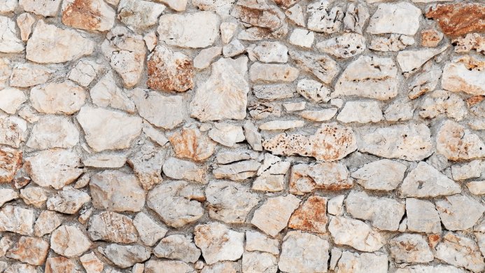 Close up of a stone wall with beige and brown stones