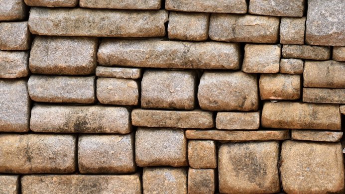 A close-up of a stone wall, showing the texture and construction