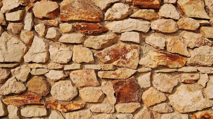 Close-up of a stone wall with varying sizes and colors of stones