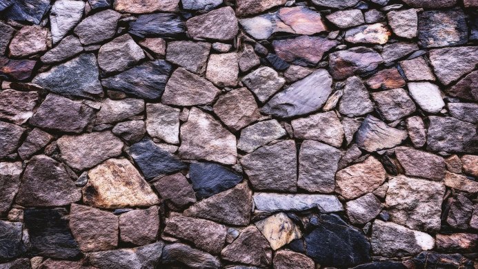 Stone wall texture with grey, brown, and blue stones