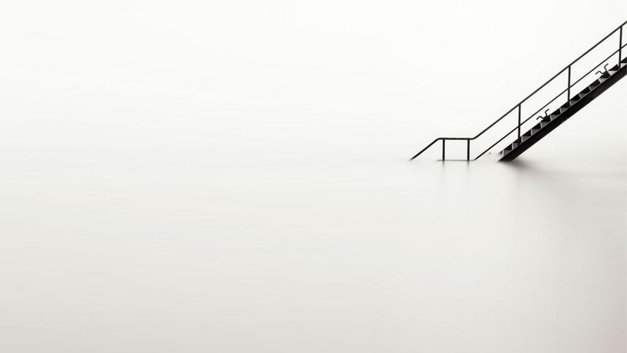 Minimalist photo of metal staircase submerged in water