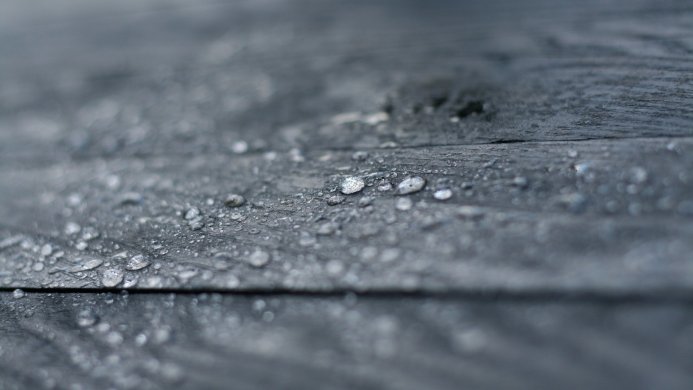 Close-up of water droplets on a gray wooden surface