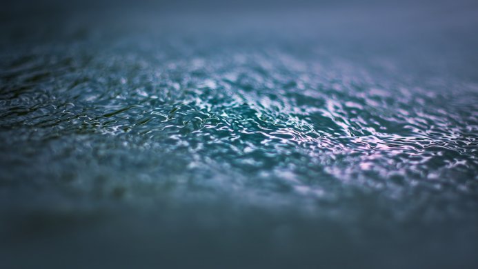 Close-up of water surface with ripples in shades of blue and teal