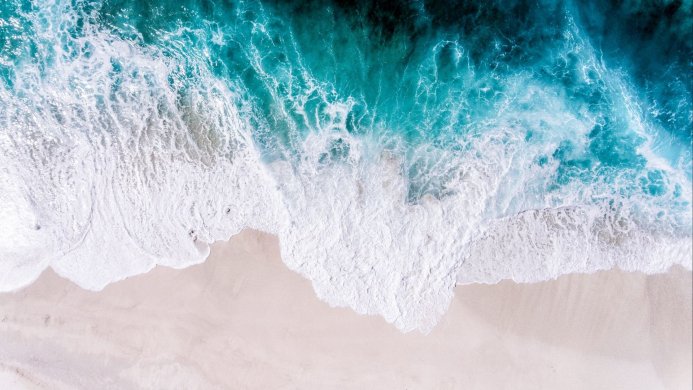 Aerial view of waves crashing on a sandy beach
