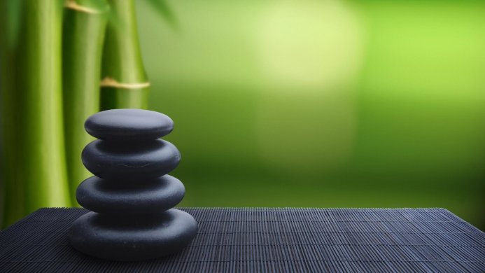 Stack of black stones with green bamboo background