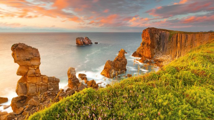Coastal landscape with cliffs and sea during a warm sunrise or sunset