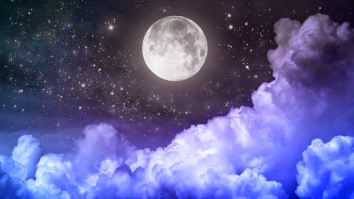 Full moon in the night sky above blue and purple clouds with stars