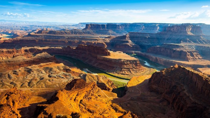 A grand canyon landscape with a river winding through the orange rock formations
