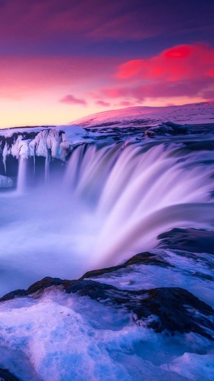 Icy waterfall landscape with a purple and pink sunset sky