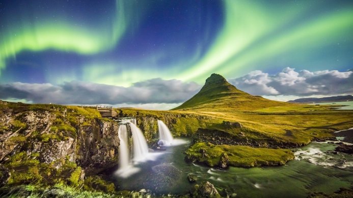 Kirkjufell mountain and waterfall in Iceland under the aurora borealis