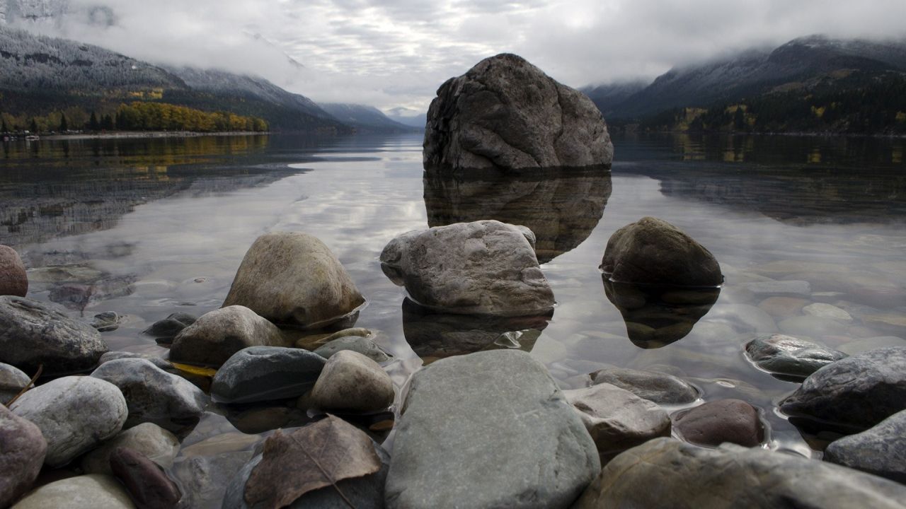 Rocks in lake with mountain backdrop