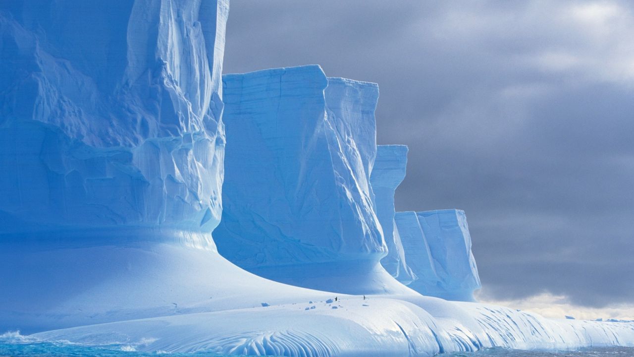 Giant iceberg under cloudy sky