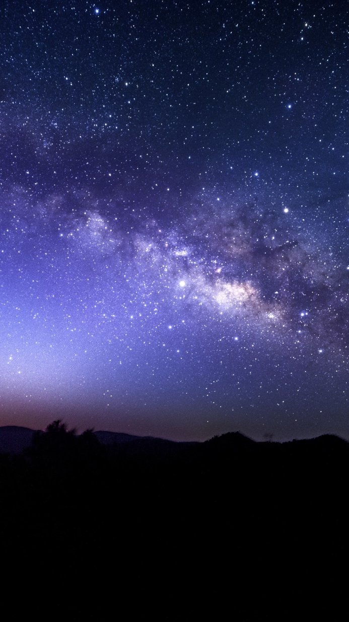 Milky Way above dark mountain silhouettes. Starry night landscape