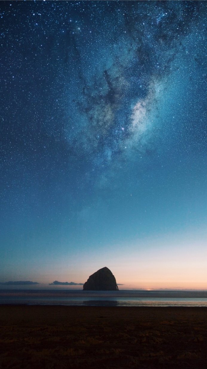 Milky Way over rock formation on a beach at night