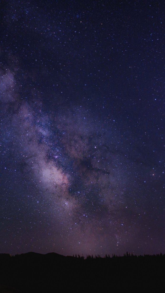 Milky Way galaxy and starry night sky over a silhouetted landscape