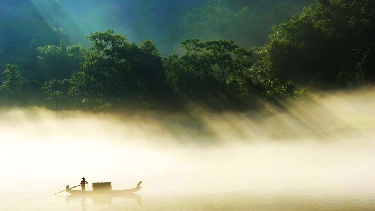 Person in boat on foggy lake