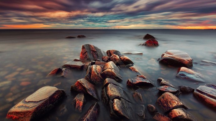 Rocks in the water at sunset with a cloudy sky