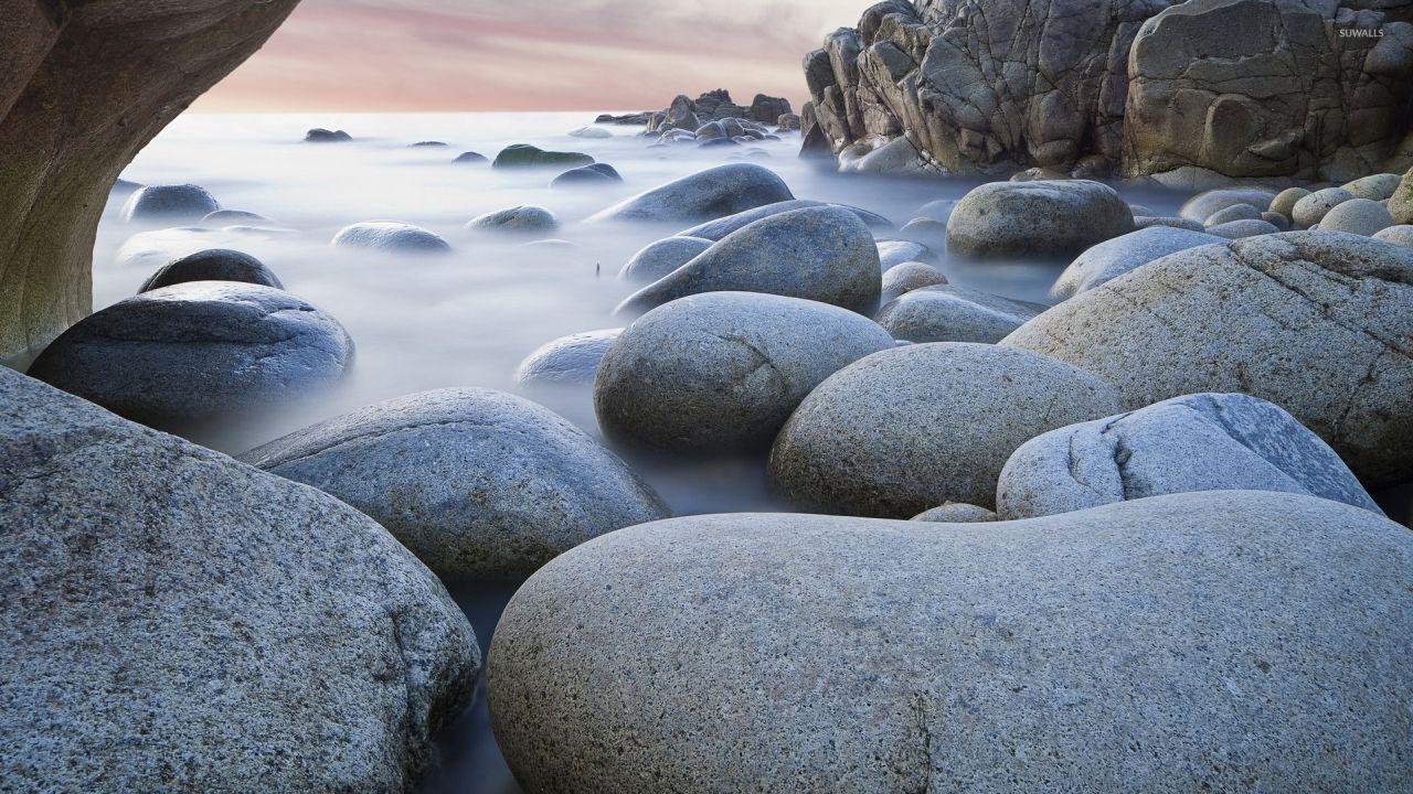 Large rocks in water on a beach