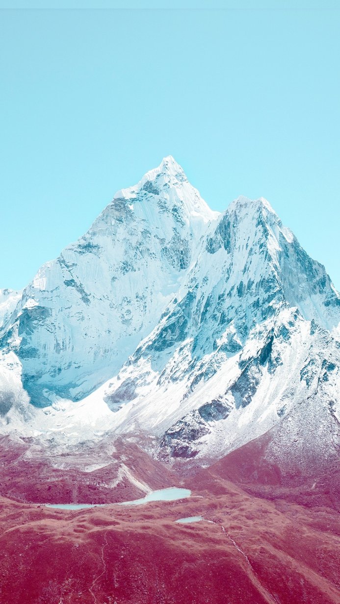 Snowy mountain with blue sky and red ground