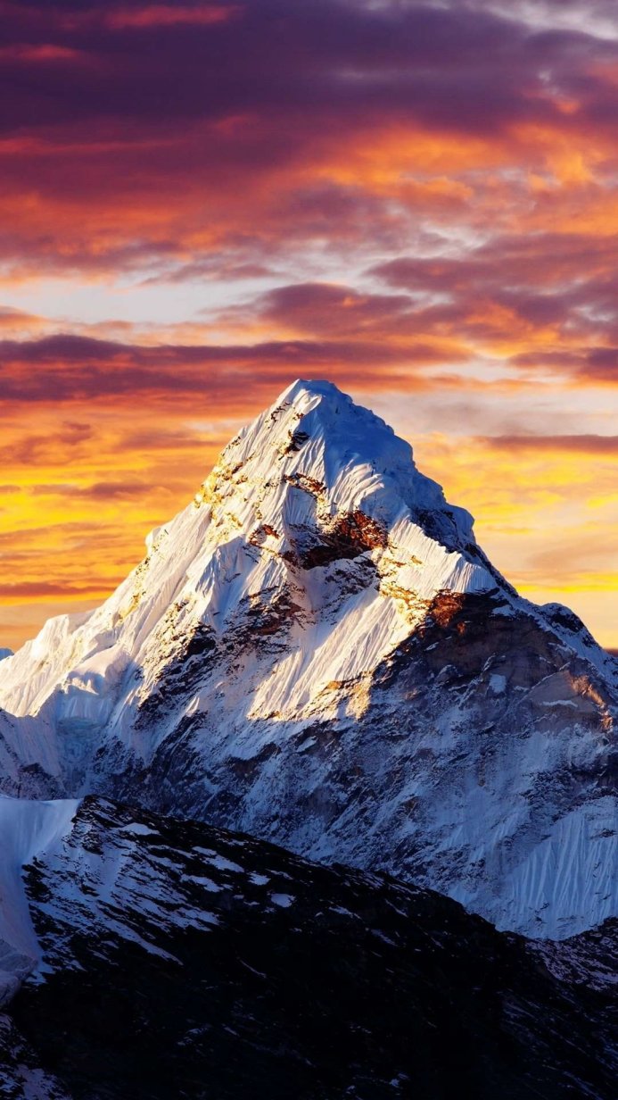 Snowy mountain peak against a colorful sunset sky