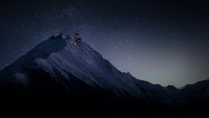 Snowy mountain range under a starry night sky