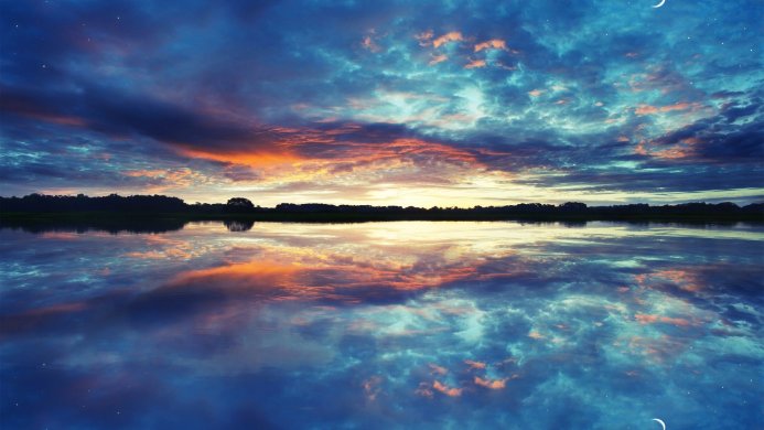 Colorful sunset reflecting on the water with trees in the background